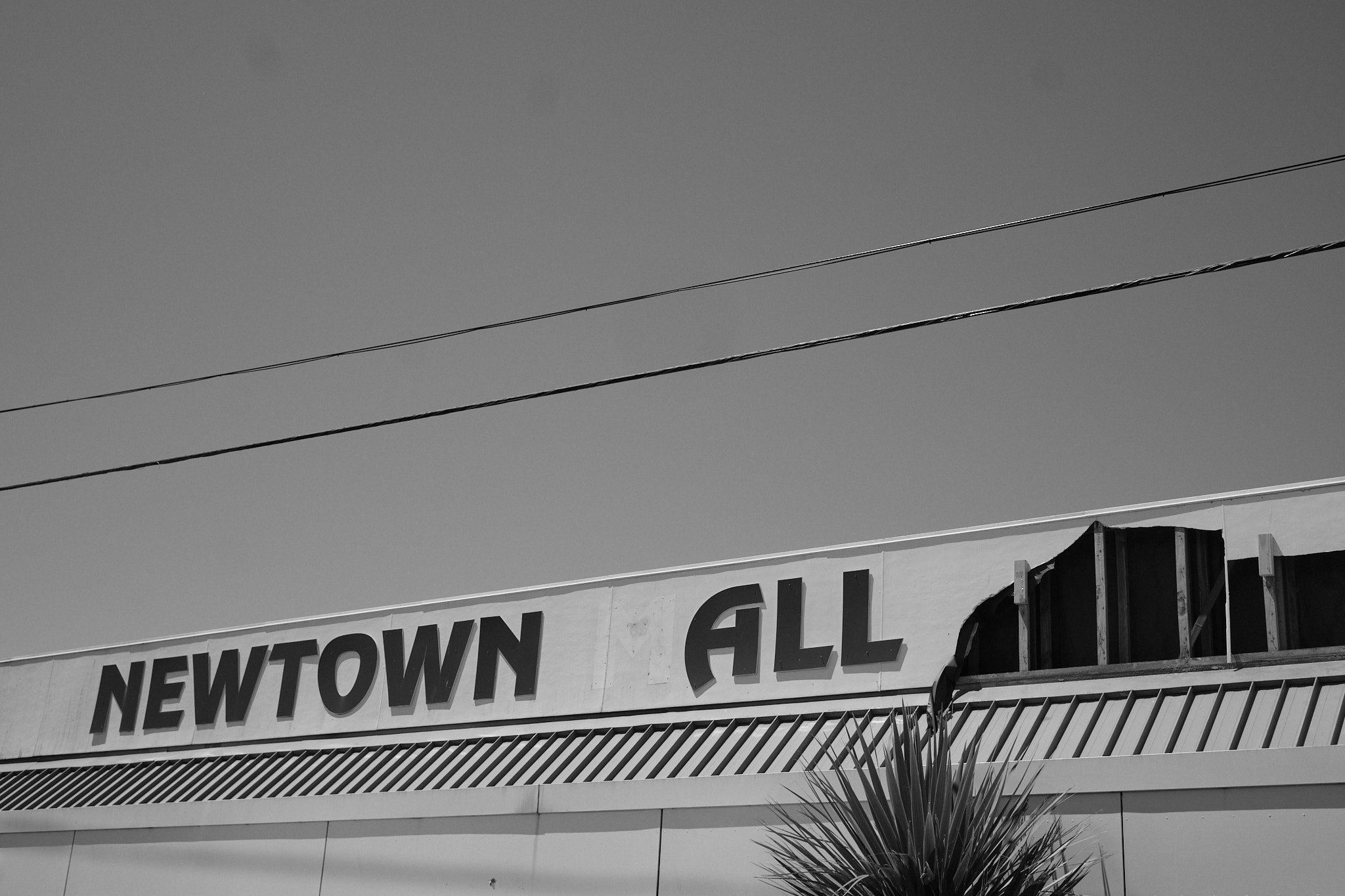 A worn down sign for the Newtown Mall now reads 'Newtown All'.